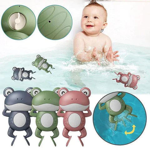 Bébé souriant dans le bain avec la grenouille nageuse verte